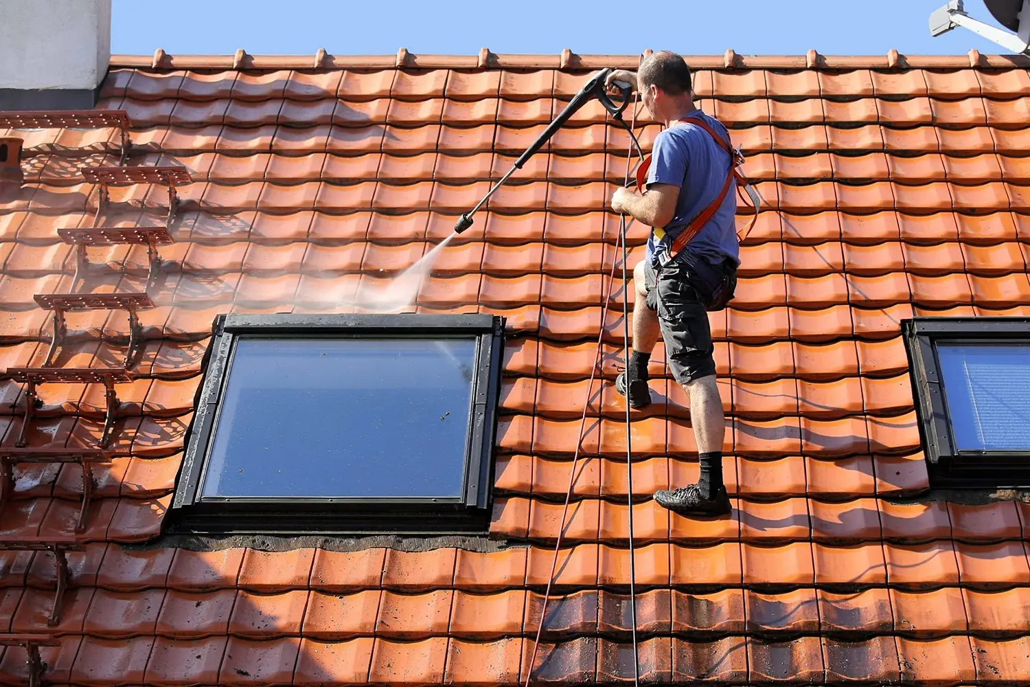 A Professional Working on Cleaning of a Roof